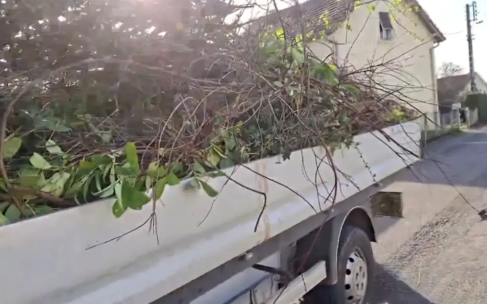 Chargement de branches dans un camion benne après une remise en état de terrain dans le Haut-Doubs